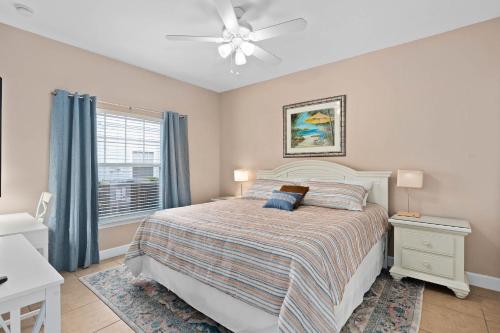 1 dormitorio con 1 cama y ventilador de techo en Charming Townhouse with 2 King Suites & Amazing Pool only 10 Mins to Disney, en Kissimmee