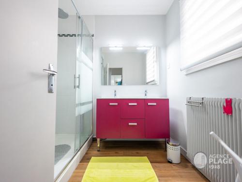 La salle de bains est pourvue d'une armoire rouge et d'un miroir. dans l'établissement Appartement moderne 80m² avec wifi, lave-vaisselle, balcon et vue mer - FR-1-197-539, à Les Sables-dʼOlonne