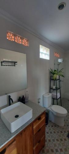 a bathroom with a white sink and a toilet at Surf & Party - Hostel Somewhere Else in Canggu
