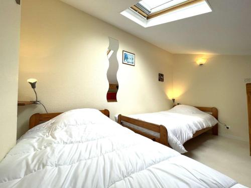 2 Betten in einem Schlafzimmer mit Dachfenster in der Unterkunft Maison T2 mezzanine avec piscine, à 200m de la mer, Bretignolles-sur-Mer - FR-1-224A-54 in Brétignolles-sur-Mer