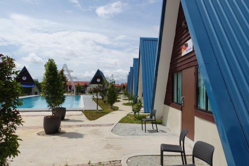een binnenplaats met een zwembad en stoelen en een gebouw bij SENTA Adventure Camp & Resort in Kampong Minyak Beku