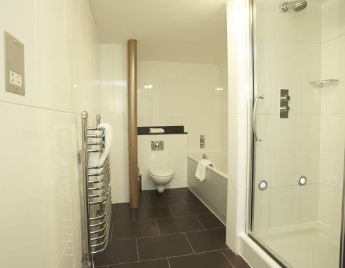 a white bathroom with a toilet and a shower at Salthouse Harbour Hotel in Ipswich