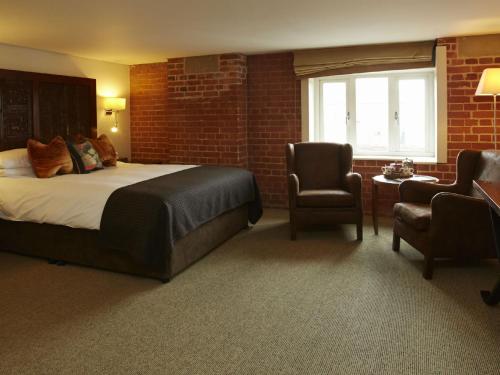 a hotel room with a bed and a chair at Salthouse Harbour Hotel in Ipswich