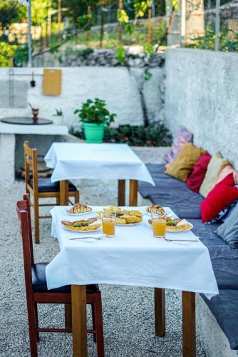 two tables with plates of food and drinks on them at Patio Rooms Gjirokaster in Gjirokastër