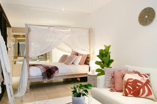 a bedroom with a canopy bed with pink pillows at 128 Santai - Stylish Resort Apartment by uHoliday in Casuarina