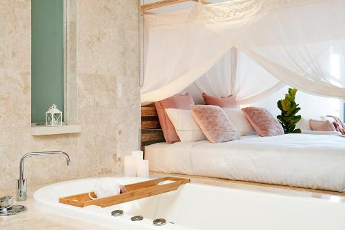 a bedroom with a bed and a bath tub at 128 Santai - Stylish Resort Apartment by uHoliday in Casuarina