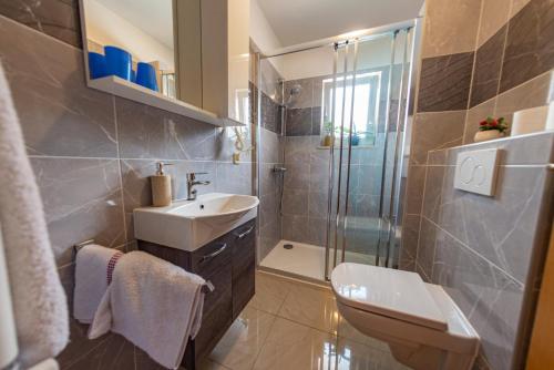 a bathroom with a sink toilet and a shower at Apartments Anita in Pula