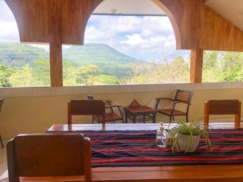 a dining room with a table and chairs and a large window at Silverin Bajawa in Bajawa