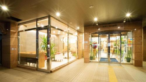 Toyoko Inn Hokkaido Kitami Ekimae في كيتامي: واجهة متجر بأبواب زجاجية ونباتات خزف