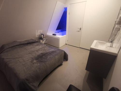 a bedroom with a bed and a bathroom with a sink at Wellness Suite Utrecht in Utrecht