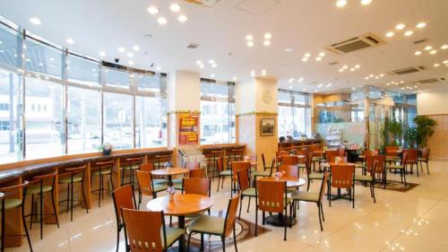 un restaurante con mesas y sillas y un bar en Toyoko Inn Hokkaido Okhotsk Abashiri Ekimae, en Abashiri