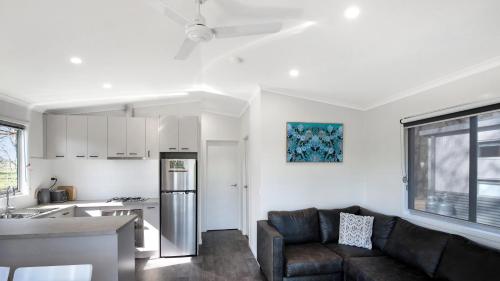 a living room with a couch and a kitchen at Colac Colac Caravan Park in Corryong
