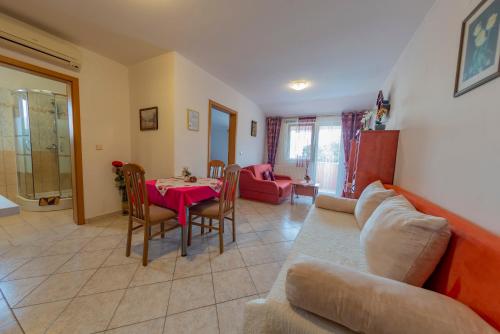a living room with a couch and a table at Apartments Anita in Pula