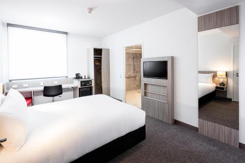 una camera d'albergo con letto e TV di Ibis Mackay a Mackay