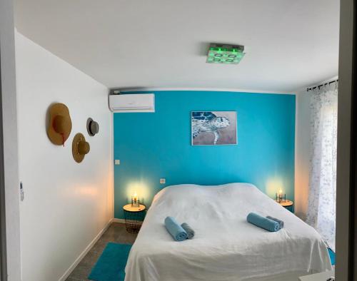 une chambre avec un lit avec un mur bleu dans l'établissement Villa Etoile, à Cabasse