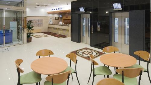 a lobby with tables and chairs in a building at Toyoko Inn Hokkaido Asahikawa eki Higashi guchi in Asahikawa