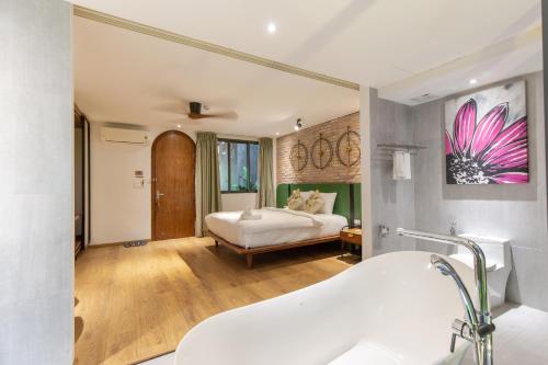 a bathroom with a bed and a sink in a room at Seaforest Hotel by Haviland in Da Nang