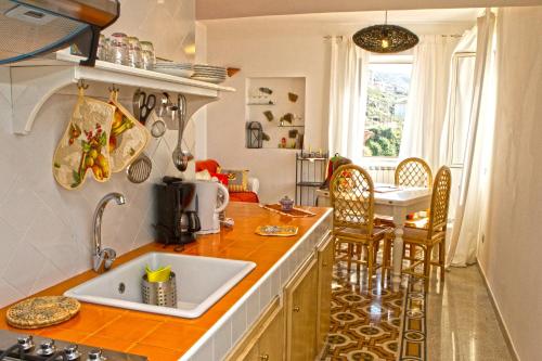 a kitchen with a sink and a table with chairs at Apartment Casa Beatrice in Pizzo