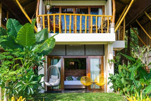 a porch of a house with a balcony at Fox & The Firefly Cottages in Loboc