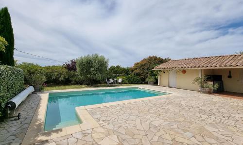 a swimming pool in front of a house at Le Bariole, luxury villa with heated pool in Cesseras