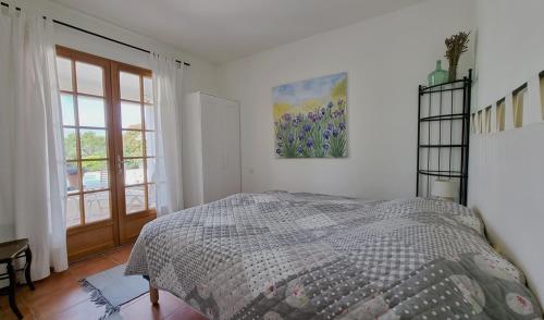 a white bedroom with a bed and a window at Le Bariole, luxury villa with heated pool in Cesseras