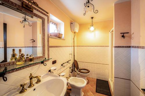 a bathroom with a sink and a toilet and a mirror at Villa Lara in Tortorici