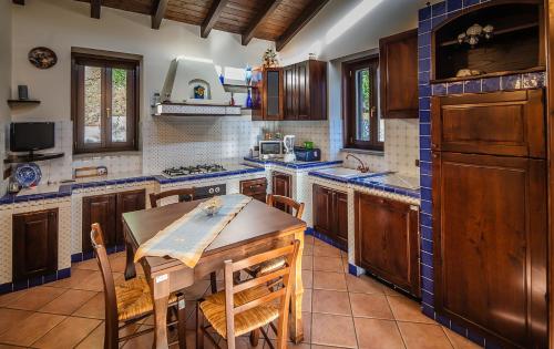 a kitchen with wooden cabinets and a wooden table at Villa Lara in Tortorici