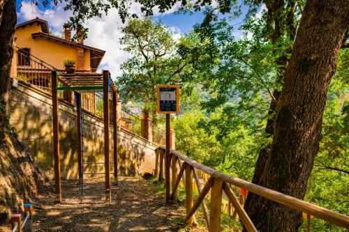 a wooden fence next to a tree and a building at Villa Lara in Tortorici