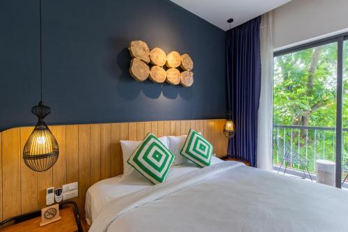 a bedroom with a bed with logs on the wall at Seaforest Hotel by Haviland in Da Nang