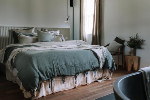比奇沃斯The Benev - Wellness Accommodation and Spa Beechworth的卧室里有一张大床，上面铺着绿色毯子