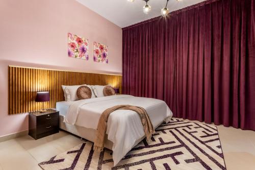 a bedroom with a large bed with red curtains at Live in style. Luxury destination - OIA - Motor City in Dubai