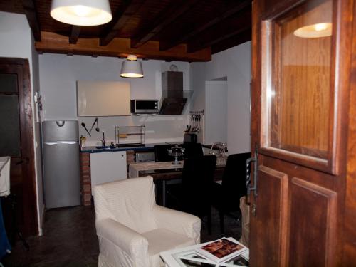 ein Wohnzimmer mit einer Küche und einem Tisch mit Stühlen in der Unterkunft Casa Rural La Cabaña del Valleyu in Sotres