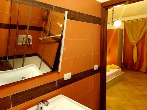 uma casa de banho com um lavatório, um espelho e uma banheira em Room in Guest room - Spend little and enjoy Sicily em Calatabiano