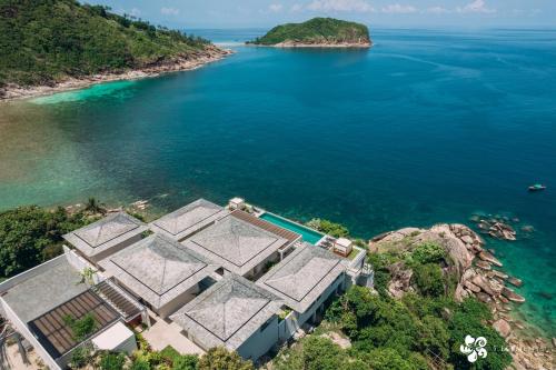 an aerial view of a house on a rock in the ocean at Bay Villas Koh Phangan in Salad Beach