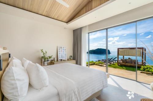 a bedroom with a large bed and a large window at Bay Villas Koh Phangan in Salad Beach