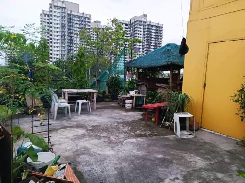 un patio trasero con cenador, mesas y sillas en MJ Home en Manila