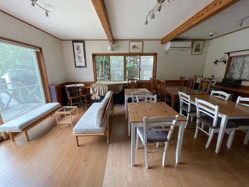 a dining room with wooden tables and chairs at ヴィラコテージ Chaconne Karuizawa in Karuizawa