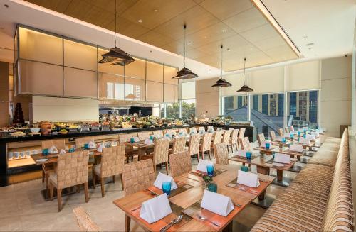 a large dining room with tables and chairs at Eastin Grand Hotel Sathorn in Bangkok