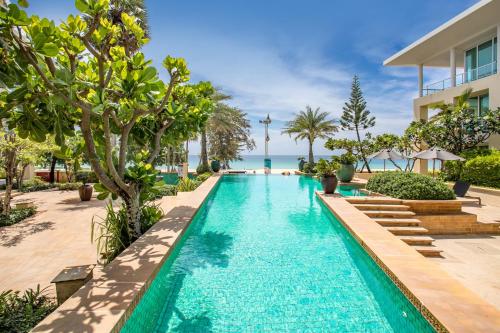an infinity pool at a resort with the ocean in the background at Happy Apartment on Karon Beach in Karon Beach