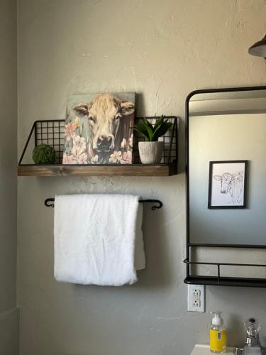 une photo d'une vache sur un porte-serviettes dans une salle de bains dans l'établissement Millz Manor, à Fall River Mills