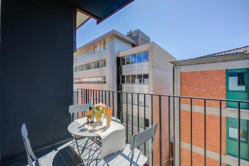un balcone con tavolo e sedie e un edificio di Boutique Homes - Happy Rentals a Lugano