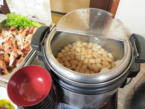 a food processor with potatoes in it next to a plate of food at Tabist Business Hotel Takizawa Takasaki Station Nishiguchi in Takasaki