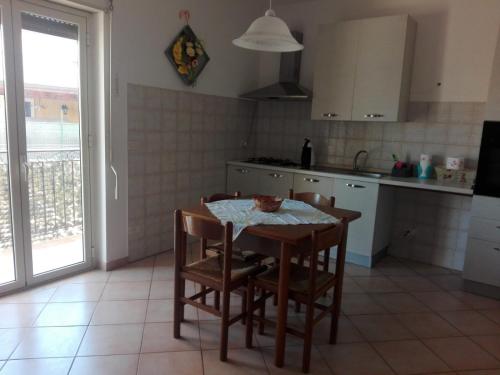eine Küche mit einem Tisch und Stühlen sowie einem Tisch und einem Fenster in der Unterkunft Villa Stella in Campobello di Licata