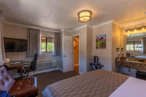 a hotel room with a bed and a desk and a sink at Cedars Resort in Sedona