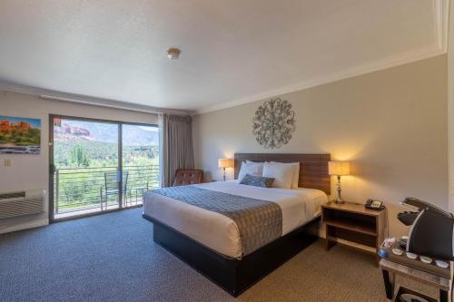 a hotel room with a bed and a balcony at Cedars Resort in Sedona