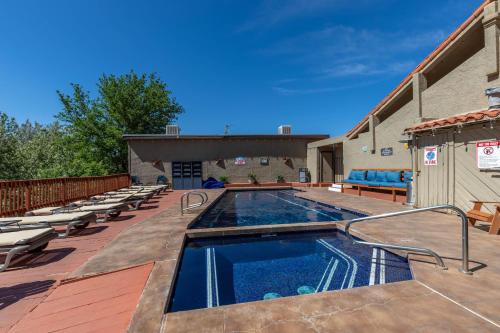 a swimming pool on a deck with lounge chairs next to a building at Cedars Resort in Sedona