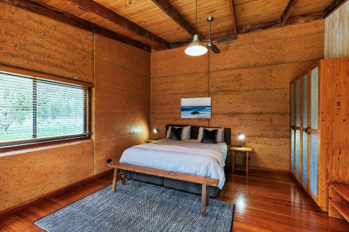 a bedroom with a bed in a room with wooden walls at Burnside Organic Farm in Margaret River Town