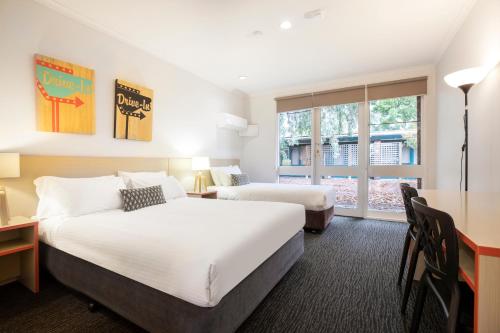 a hotel room with two beds and a window at Burvale Hotel in Nunawading