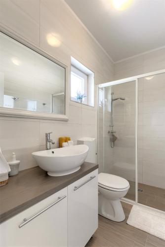 a white bathroom with a sink and a toilet at Studio Mare in Zadar