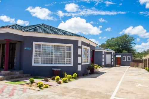 a blue house with a large window at Ramatie Guest Palace in Kasane